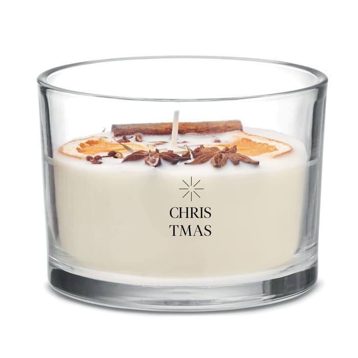 A glass candle featuring a white wax body, decorated with dried orange slices, cinnamon, and star anise.
