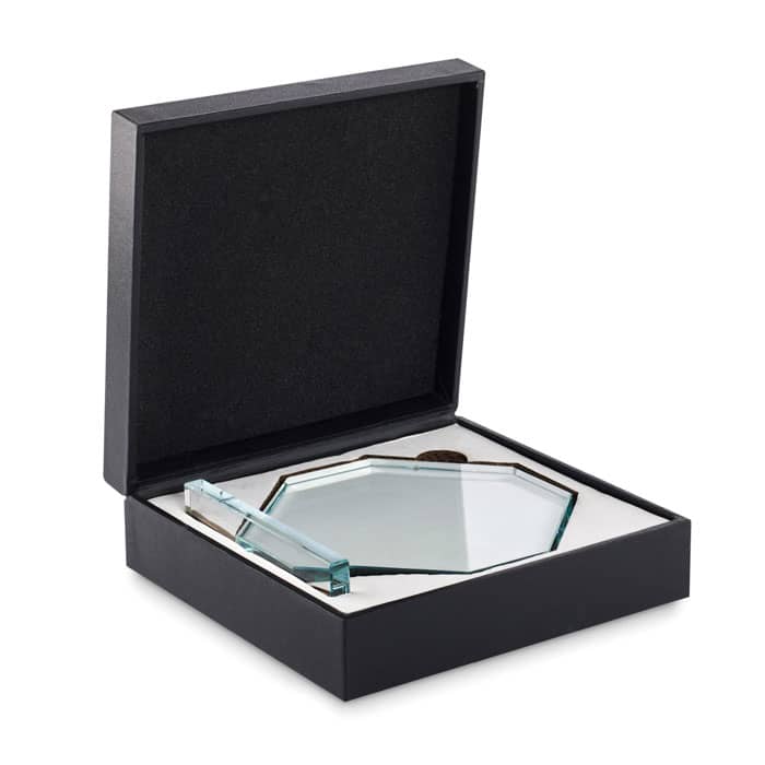 A glass award in an octagonal shape, displayed in a black gift box with a soft interior. The box has a lid.