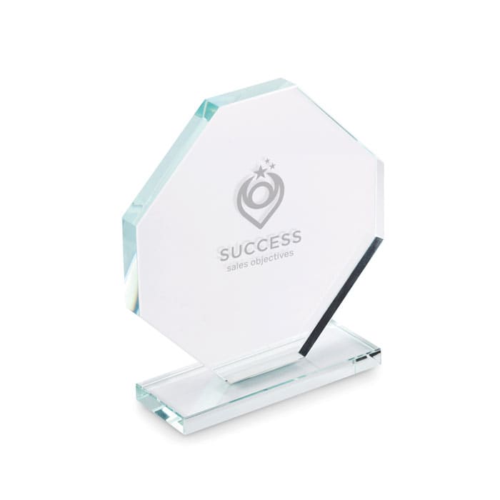A glass trophy with a hexagonal shape, featuring a base and an engraved design.