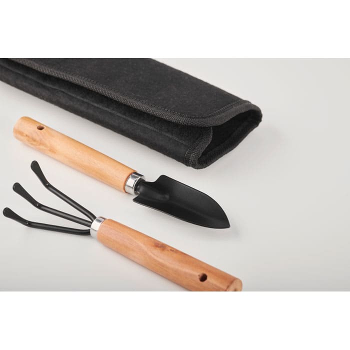 A gardening tool set featuring a black hand trowel and a three-prong cultivator with wooden handles, beside a black storage pouch.