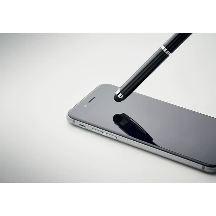 A black stylus pen resting on a smartphone screen, reflecting light in a minimalist setting.