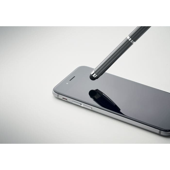 A stylus pen hovering above a sleek, black smartphone screen. The phone features a slim design and has a logo.