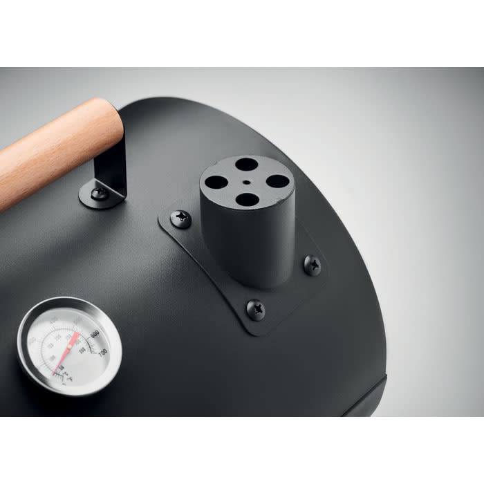 A black smoker features a wooden handle and a chimney with multiple openings, alongside a temperature gauge.