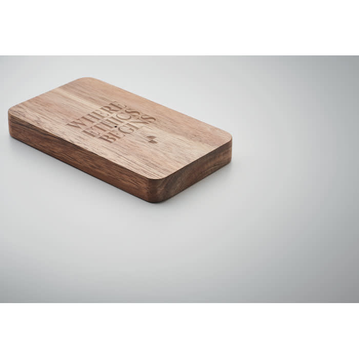 A wooden cutting board with a smooth finish, featuring an engraved phrase on the surface.