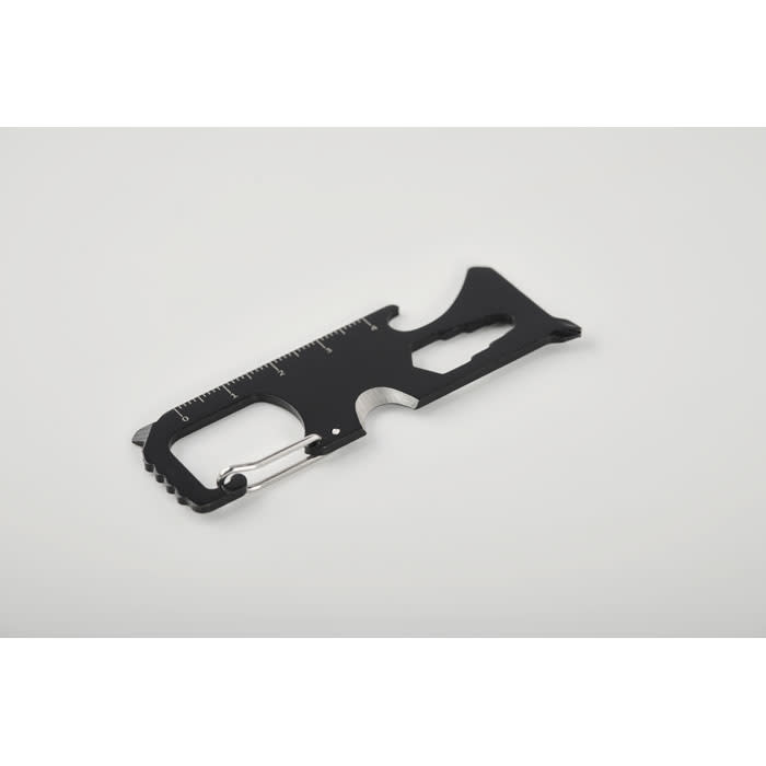 A black multi-tool with a ruler, a bottle opener, and a carabiner clip. It has a sleek, compact design.