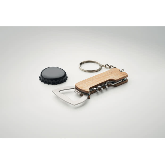 A bottle opener with a wooden handle, featuring a corkscrew and keychain, alongside a black bottle cap.