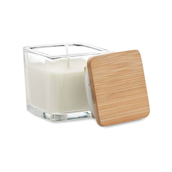 A candle in a clear square glass jar with a bamboo lid, featuring a white wax interior.