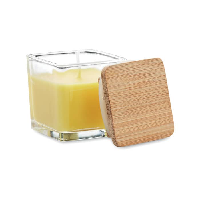 A square glass candle jar with a bamboo lid, containing a pale yellow candle.