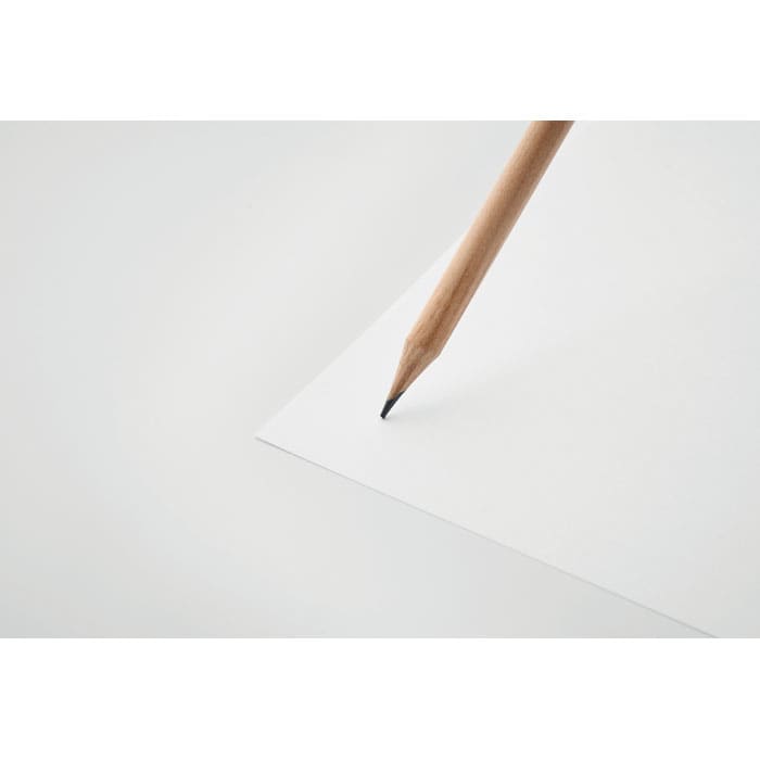A wooden pencil with a sharp tip is poised above a blank sheet of white paper.