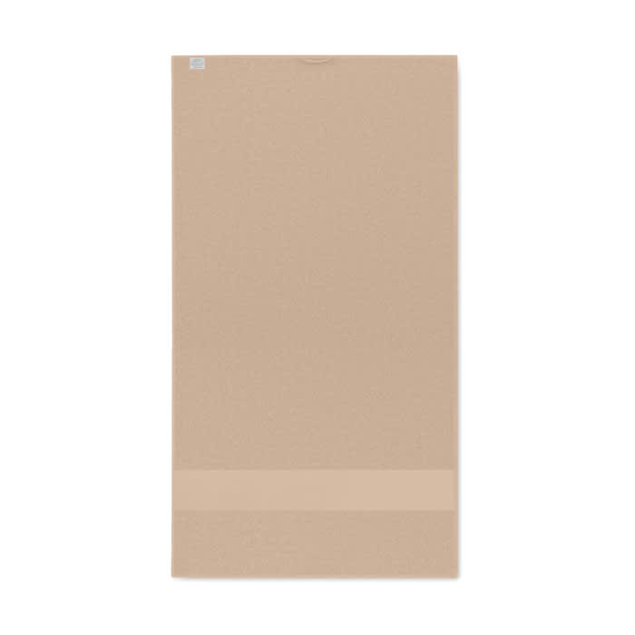 A tan yoga mat with a textured surface and a smooth bottom strip, showcasing a simple design.