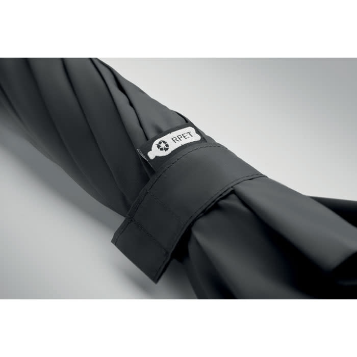 A folded black umbrella with a tag featuring a logo, made from recycled materials.
