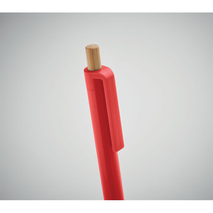 A red pen with a bamboo top and a clip, featuring a minimalist design. It includes a logo on the side.