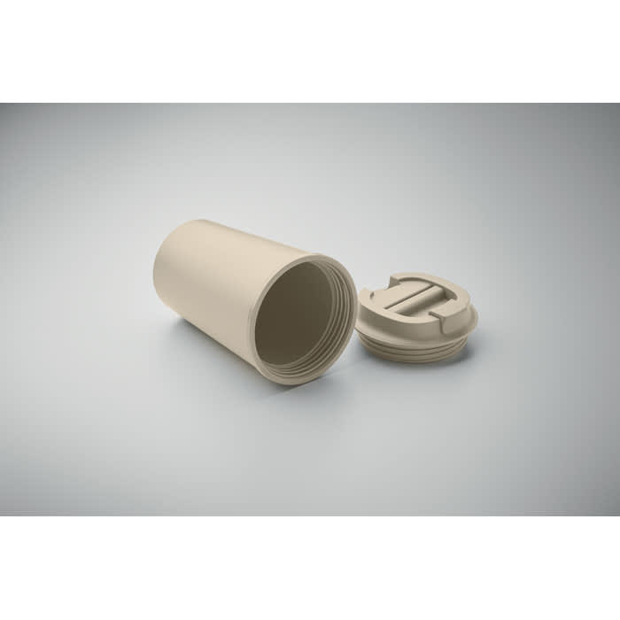 A drink bottle in a light beige colour with a screw-on lid placed beside it. The bottle is cylindrical in shape.