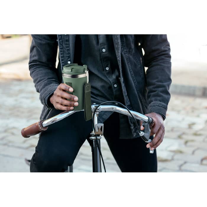 A drink bottle in olive green held by a person on a bicycle, featuring a sleek design and branding.
