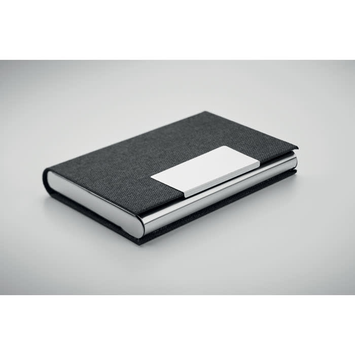 A black notebook with a textured cover and a silver plate on the front, featuring a logo.