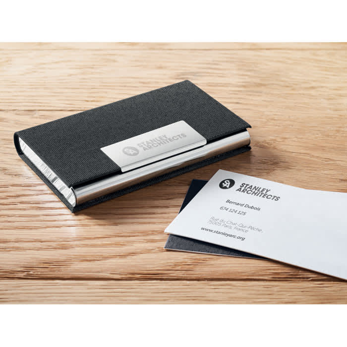 A sleek black business card holder with a silver accent, containing stacked business cards.