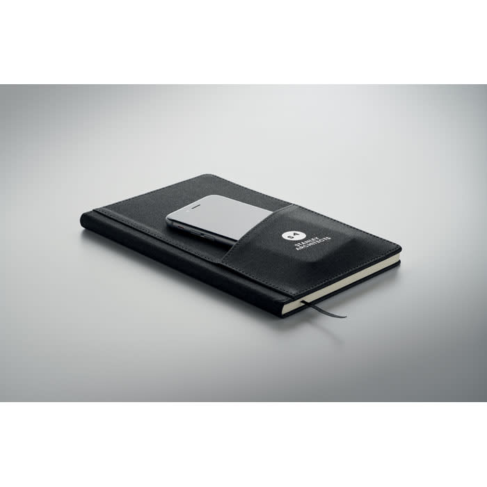 A black notebook with a phone resting on top, featuring a logo on the cover.