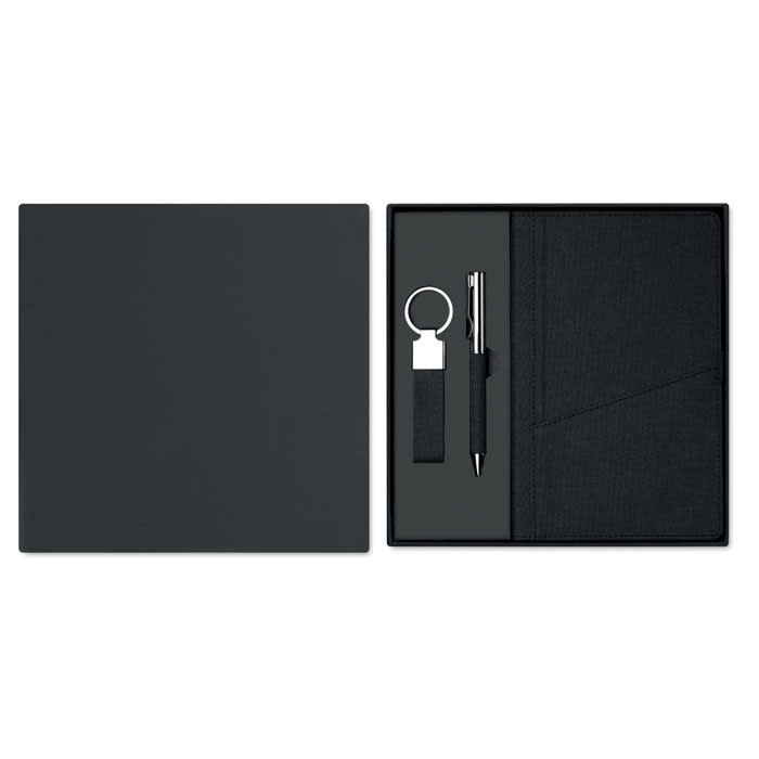 A gift set in black featuring a notebook, pen, and keyring, all arranged in a sleek presentation box.