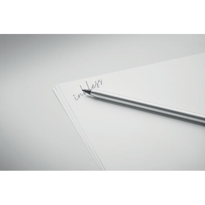 A silver pen resting on a sheet of blank paper with a faintly written word "inkless" above it.