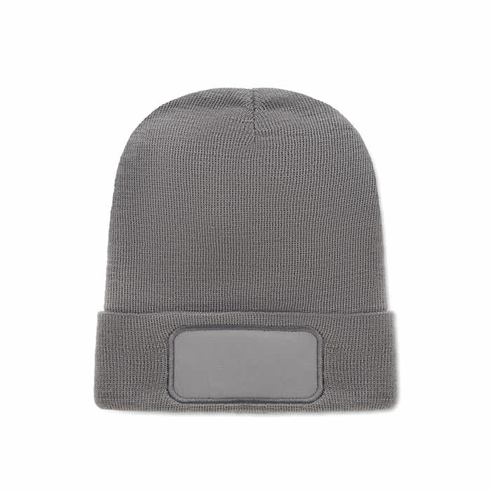 A grey beanie hat with a folded cuff and a blank patch for branding.