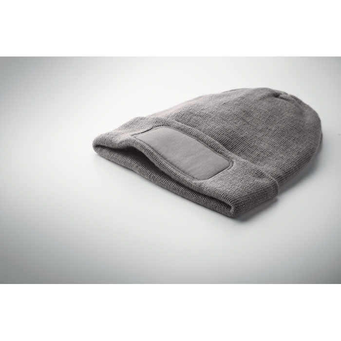 A grey beanie hat with a folded brim and a textured fabric, featuring a small branding patch.