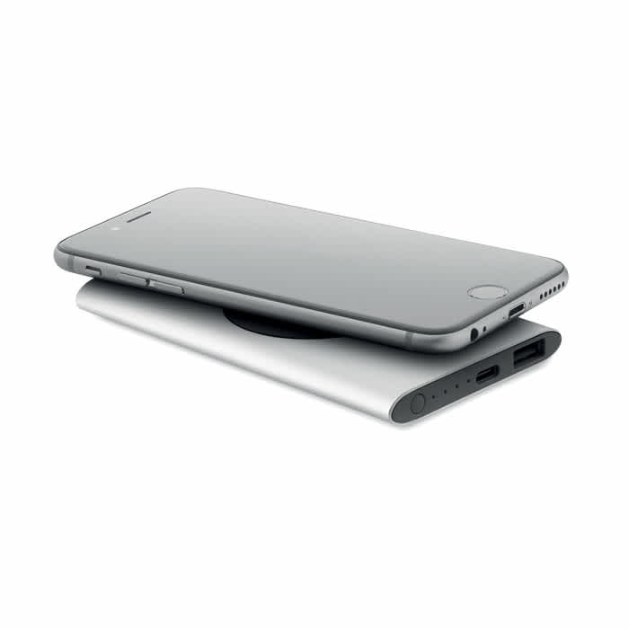 A power bank in silver with a smartphone resting on top. The power bank features two USB ports.