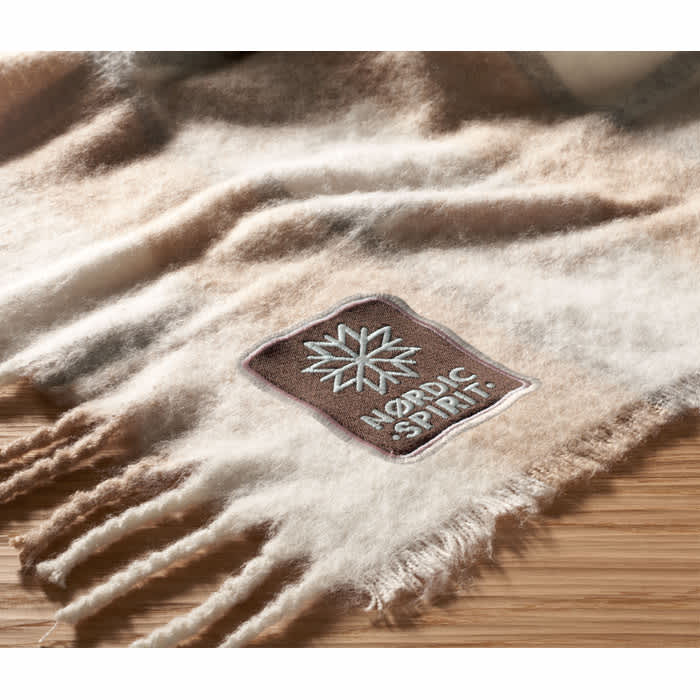 A soft, cream and brown scarf featuring a rectangular logo. The scarf has fringed edges for added texture.