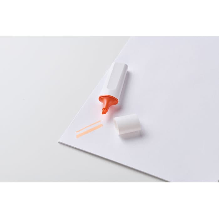A highlighter in white and orange, with a cap removed, resting on a sheet of paper alongside two orange lines.