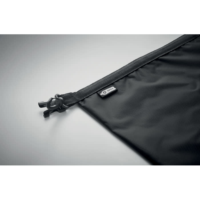 A black zippered pouch with a textured surface and a small branding tag attached.