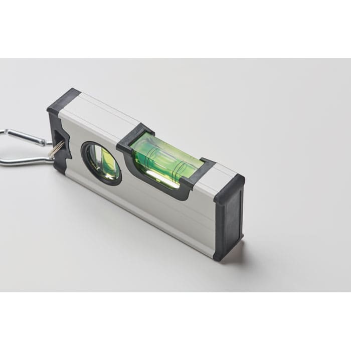 A spirit level with a silver and black casing and a green liquid vial, featuring a hanging hook.