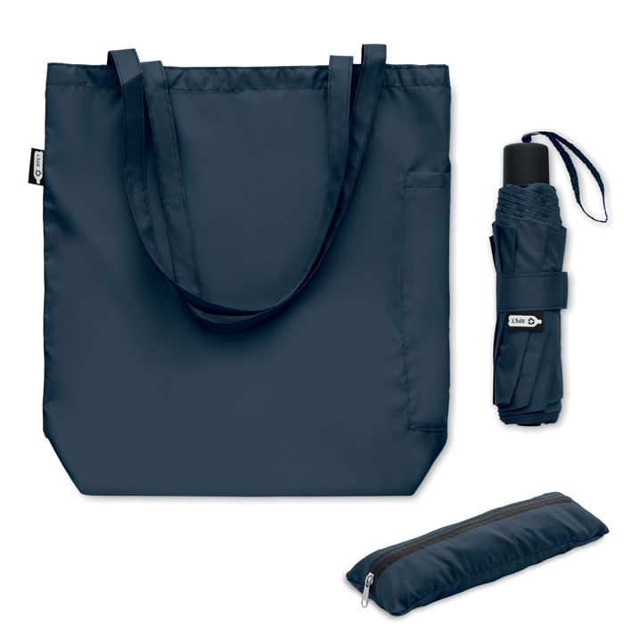 A navy blue tote bag, a folded umbrella, and a compact zip pouch displayed together. The tote has dual handles.
