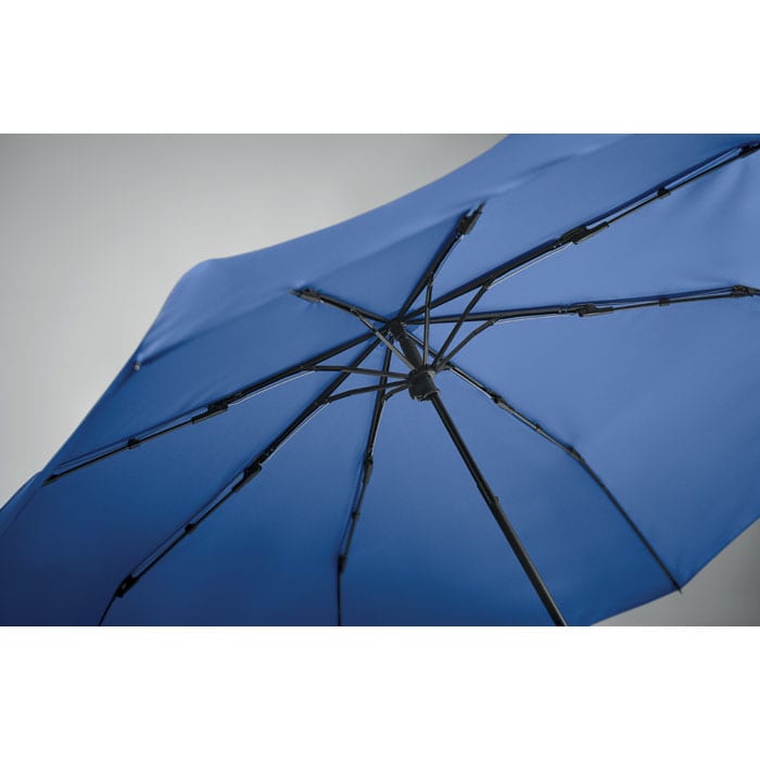 A blue umbrella with a black frame and multiple ribs, displaying its underside and structure.