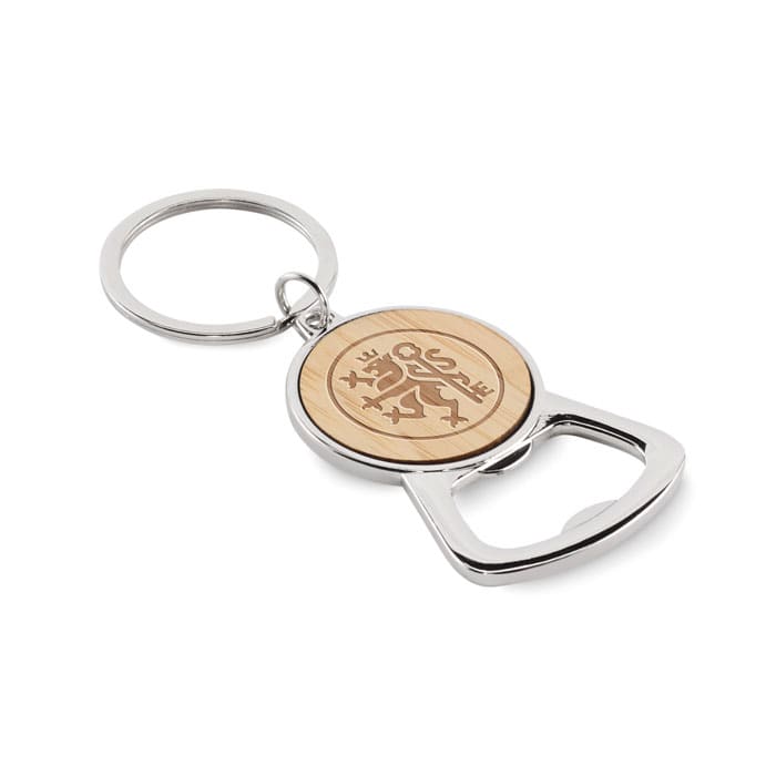 A keychain bottle opener with a wooden circular detail and a silver metal frame, featuring an emblem.