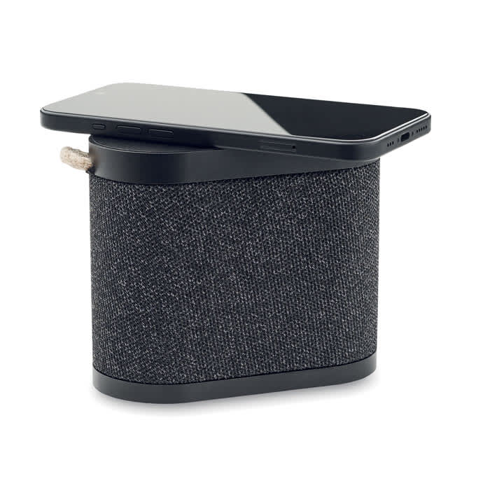 A black speaker with a textured fabric surface, featuring a smartphone resting on top.