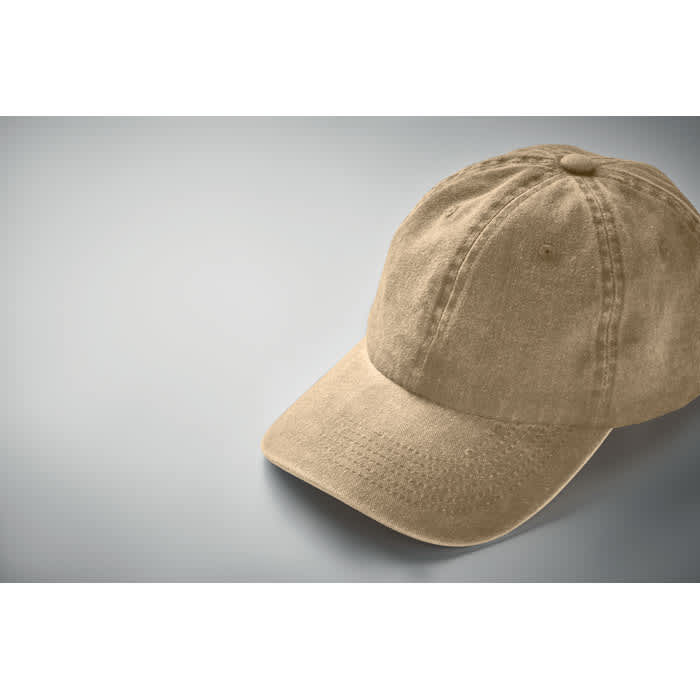 A beige cap with a curved brim and six-panel construction, featuring a logo on the front.