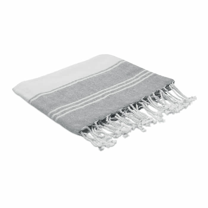 A grey and white woven towel with tassels at one end, featuring horizontal stripes and a soft texture.