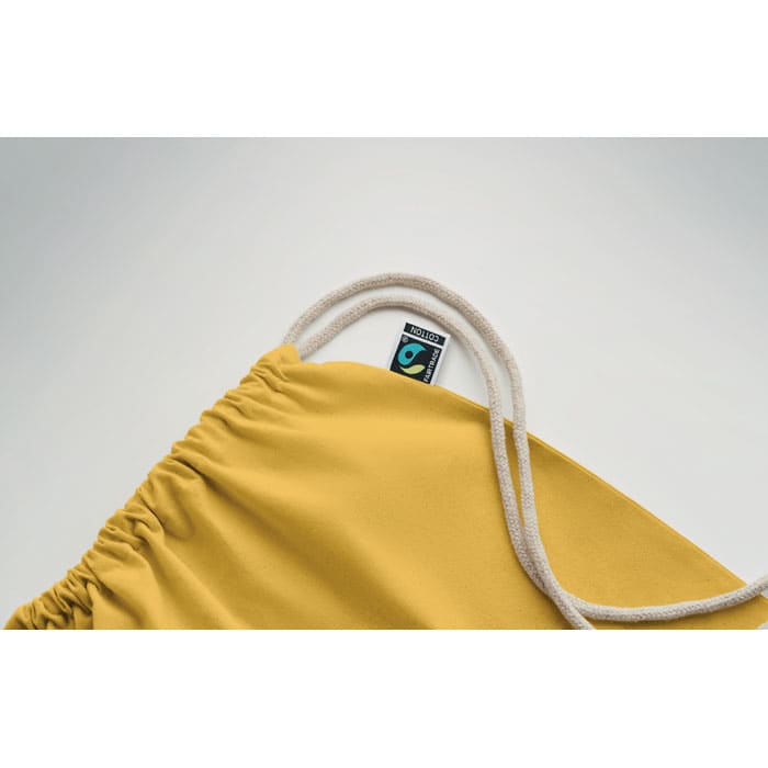 A drawstring bag in a warm yellow shade, featuring a white cord and a logo tag on the top.
