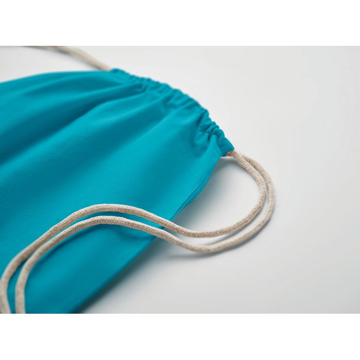 A turquoise drawstring bag with beige cords, featuring a gathered opening at the top.