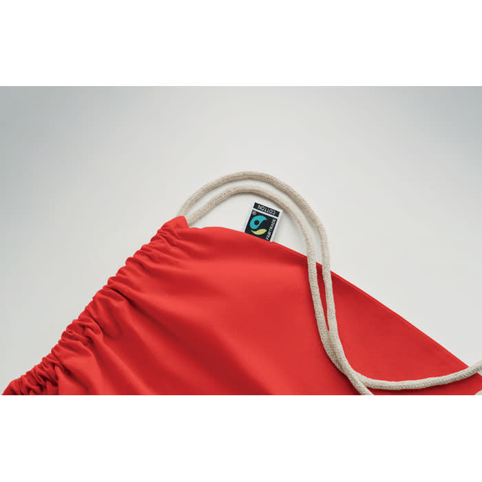 A red drawstring bag with natural cord handles and a branding tag on the inside.