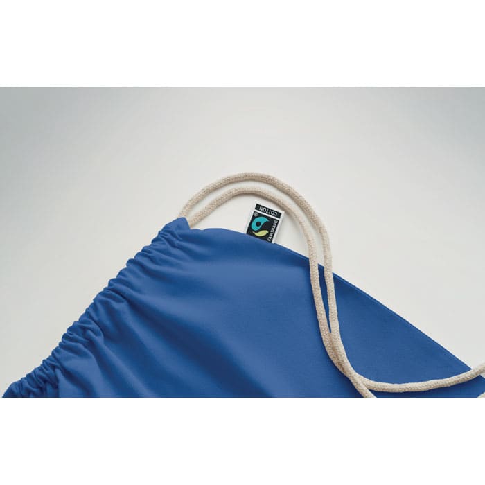 A blue drawstring bag with a cream-coloured cord and a small logo tag attached to the top.