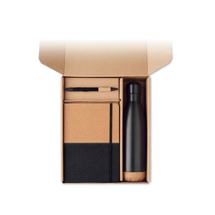 A drink bottle, a notebook with a black and cork design, and a pen inside a cardboard box.