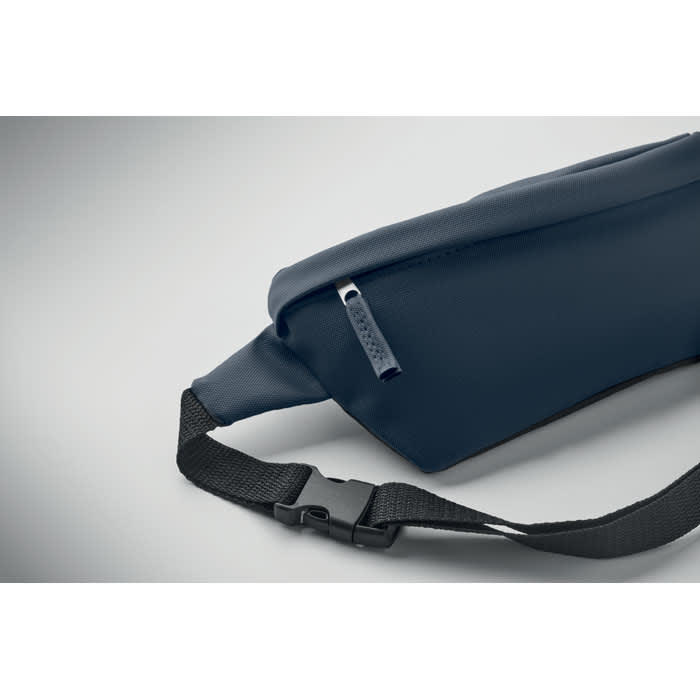 A waist bag in navy blue with a zip closure and an adjustable strap. It features a logo on the side.