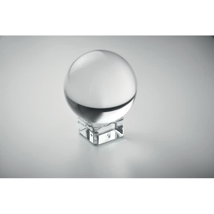 A crystal ball on a clear base, featuring a smooth, reflective surface and a minimalist design.