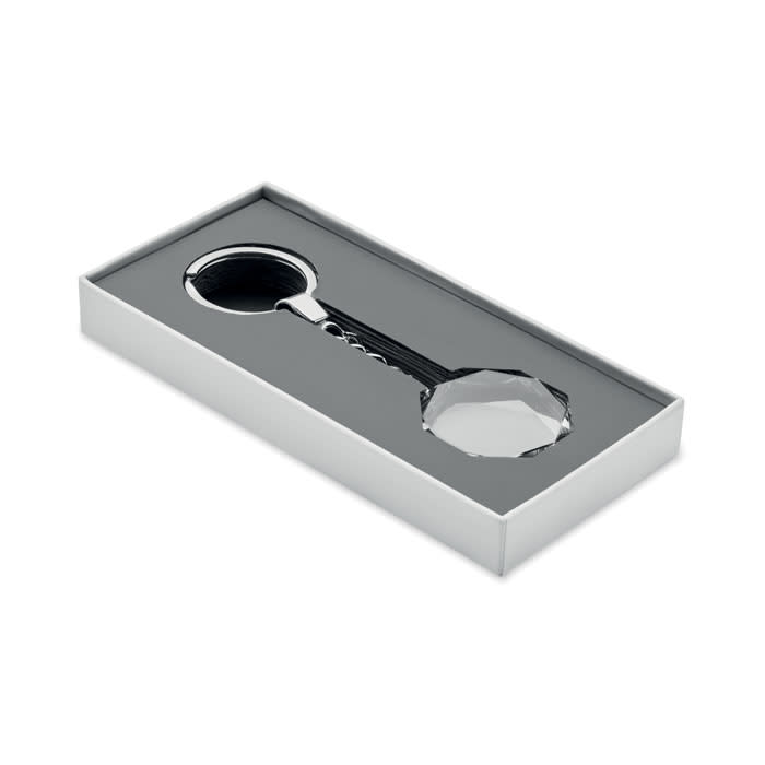 A magnifying glass with a crystal handle, presented in a sleek white box with a grey interior.