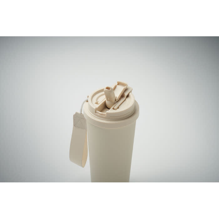 A drink bottle in a cream colour with a flip-top lid and a strap. It features a logo on the side.