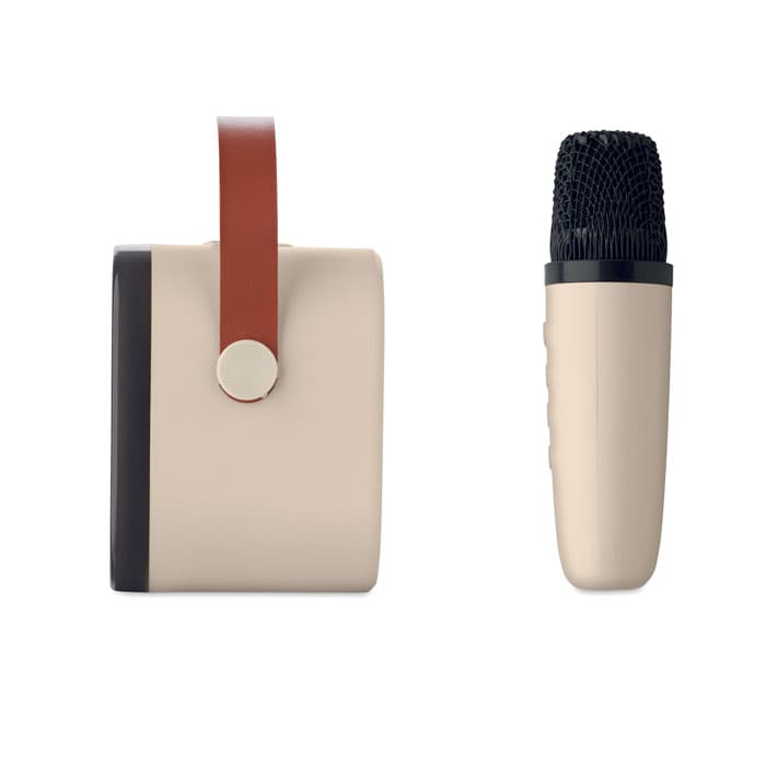A portable speaker with a beige body and a textured black microphone, featuring a brown leather strap.