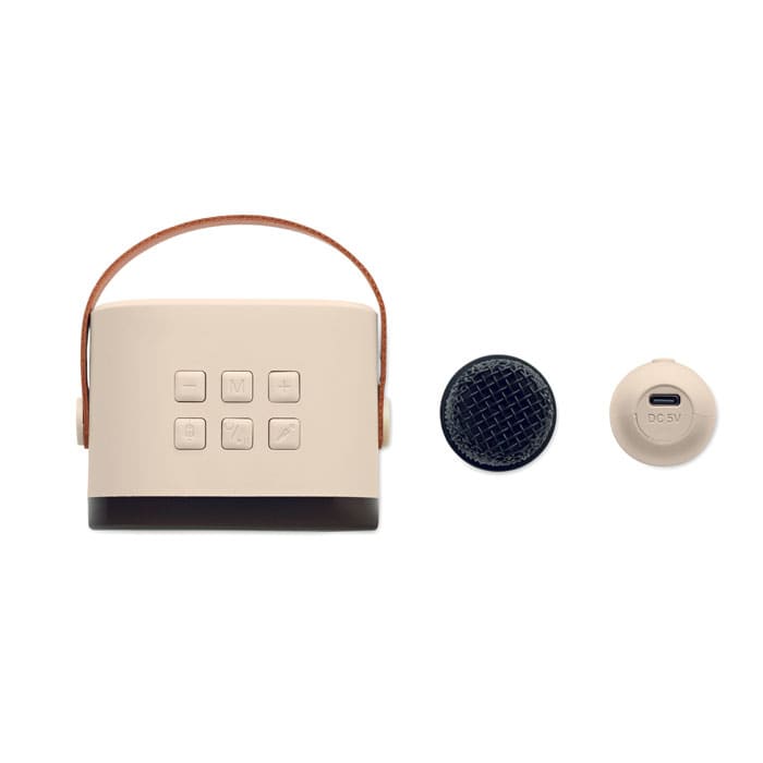 A portable speaker in cream with a brown handle, featuring buttons on the front and an attached charging port.