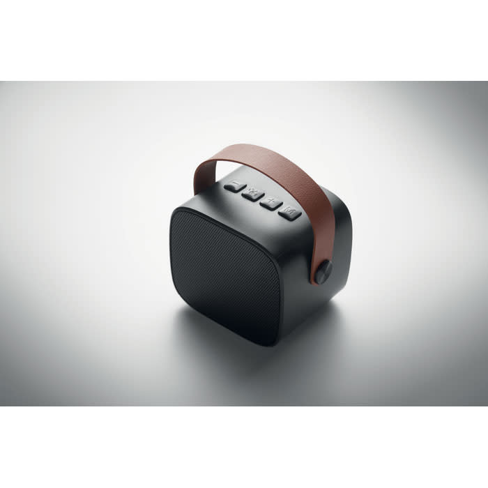 A portable speaker in black with a brown handle, featuring buttons on the top for control.