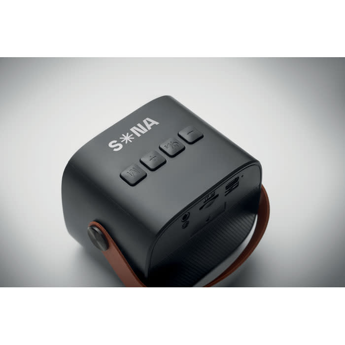 A black speaker with a brown handle, featuring control buttons on the top and branding on the side.