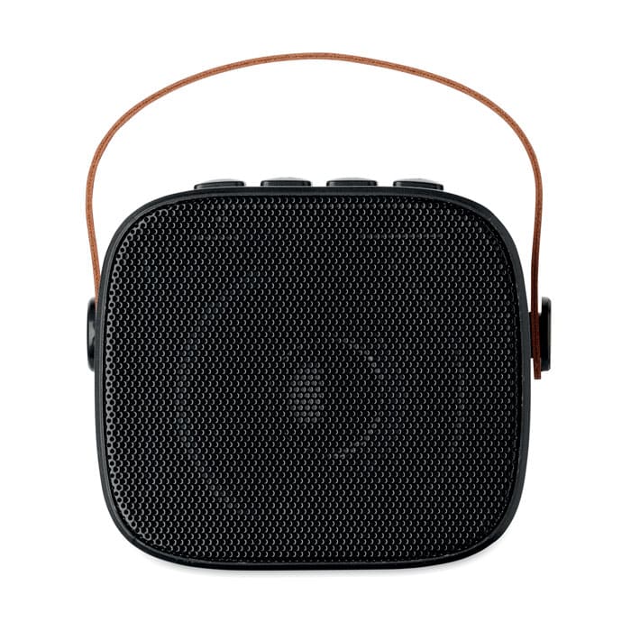 A portable black speaker with a textured surface and a brown leather strap for carrying.